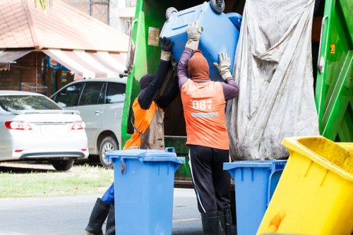 Team members wearing PPE and using trolleys during waste removal
