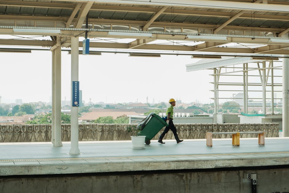 A large collection of assorted discarded household waste items arranged outdoors on a paved surface, likely set for removal or disposal. The waste includes a variety of materials such as a white plast